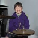Young boy in front of drum set